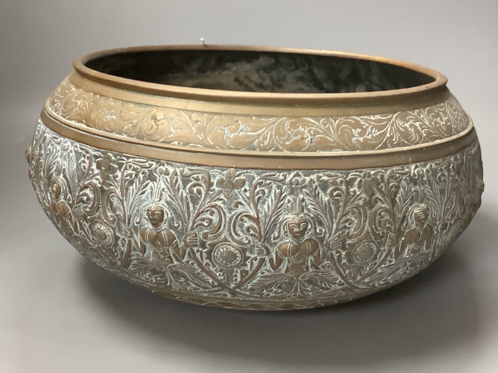 A large Eastern brass bowl cast with bands of seated deities, foliate scrolls and linear decoration and a pair of copper dishes